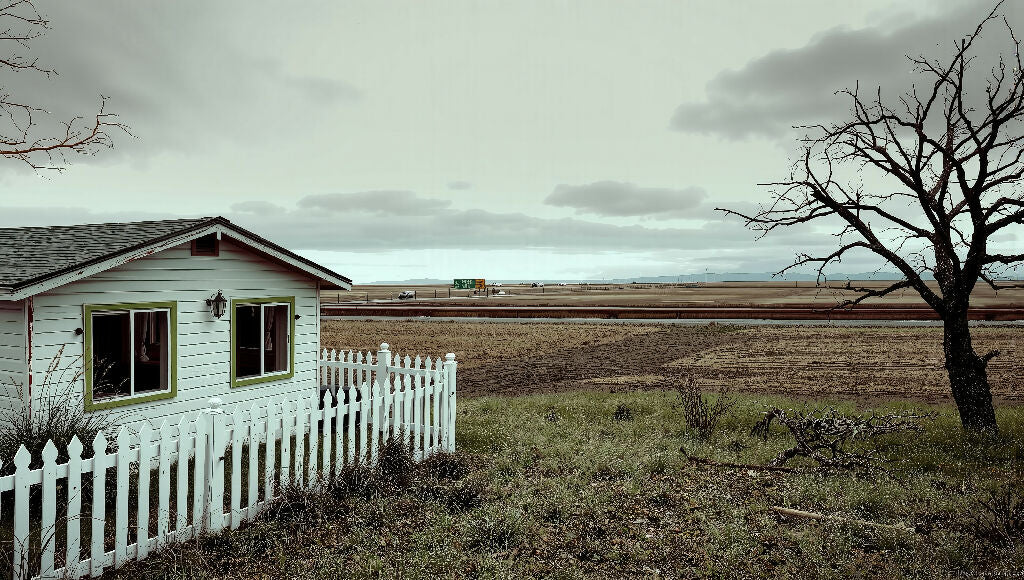 A small white house with white picket fence